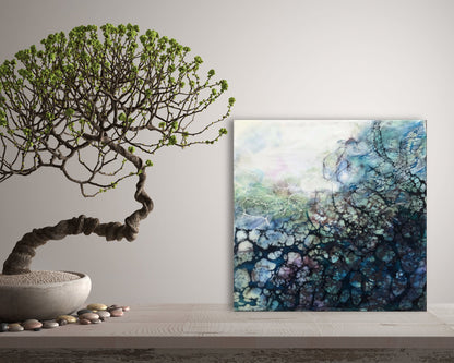 Abstraktes Enkaustik Kunstwerk mit blauen Netzstrukturen auf einem Tisch mit einem Bonsaibaum 