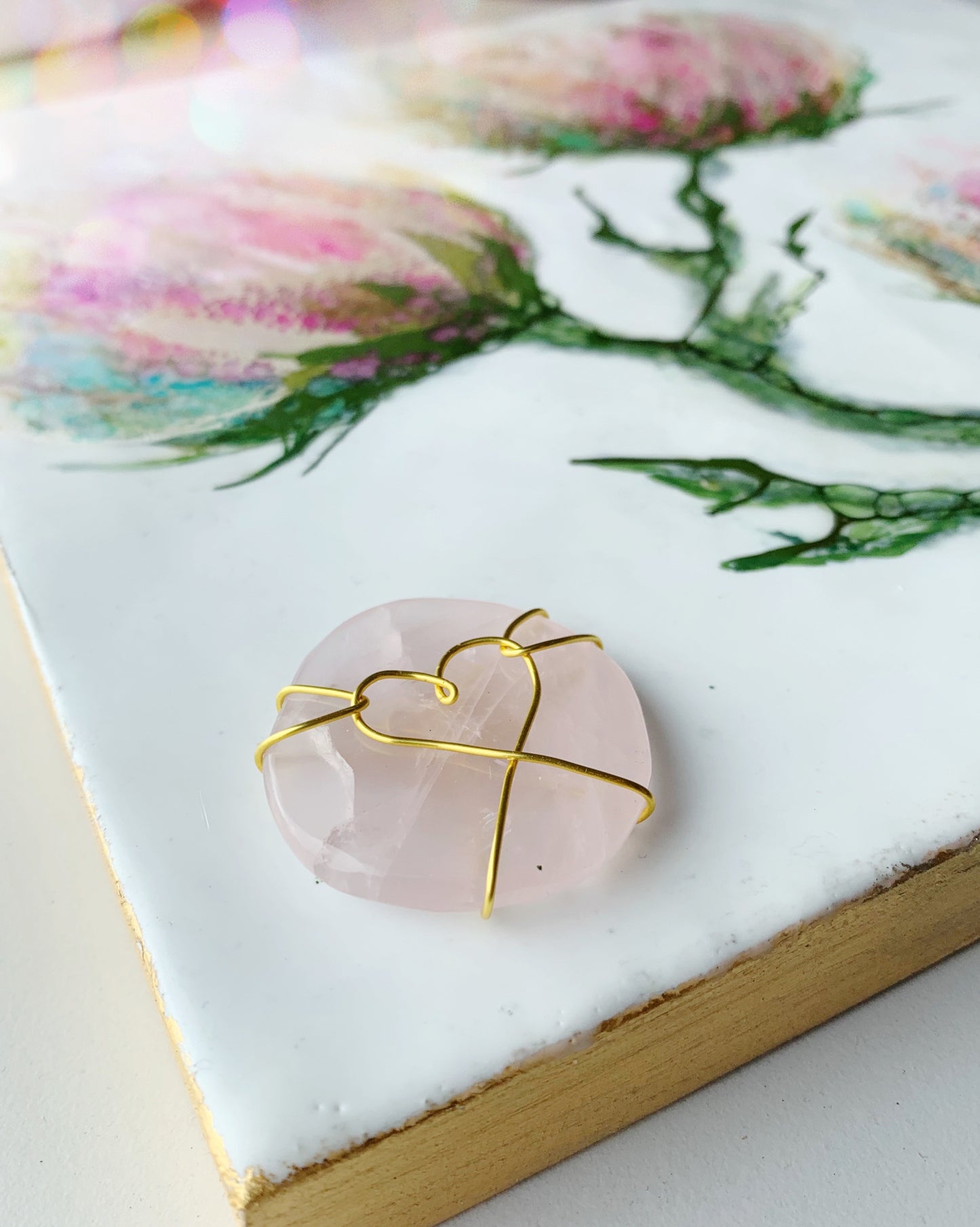 seitlicher Ausschnitt eines Enkaustik Kunstwerks zeigt lila Blumen auf weißem Grund mit einem Rosenquarz