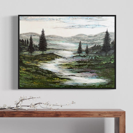 Gerahmtes Enkaustikbild an der Wand über einem Tisch zeigt eine grüne Landschaft mit einem Fluss und Bäumen